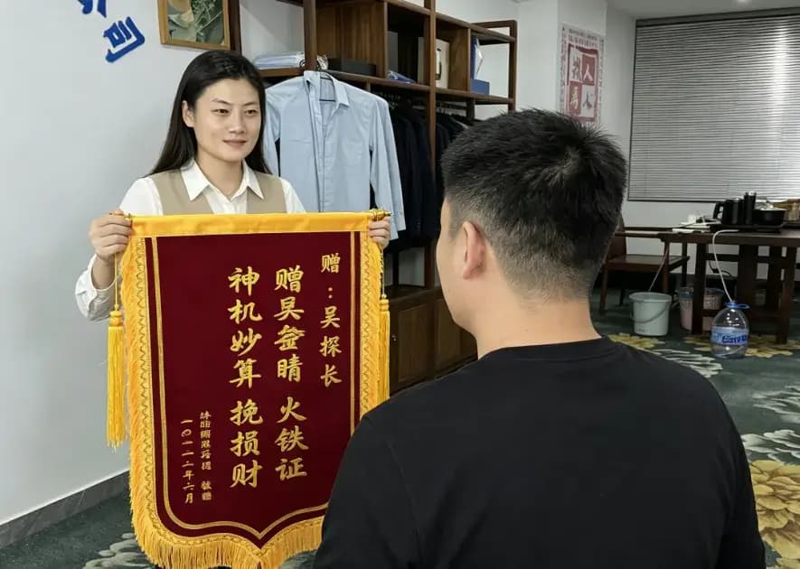 客户亲送锦旗，背景为深圳名探真实办公场地